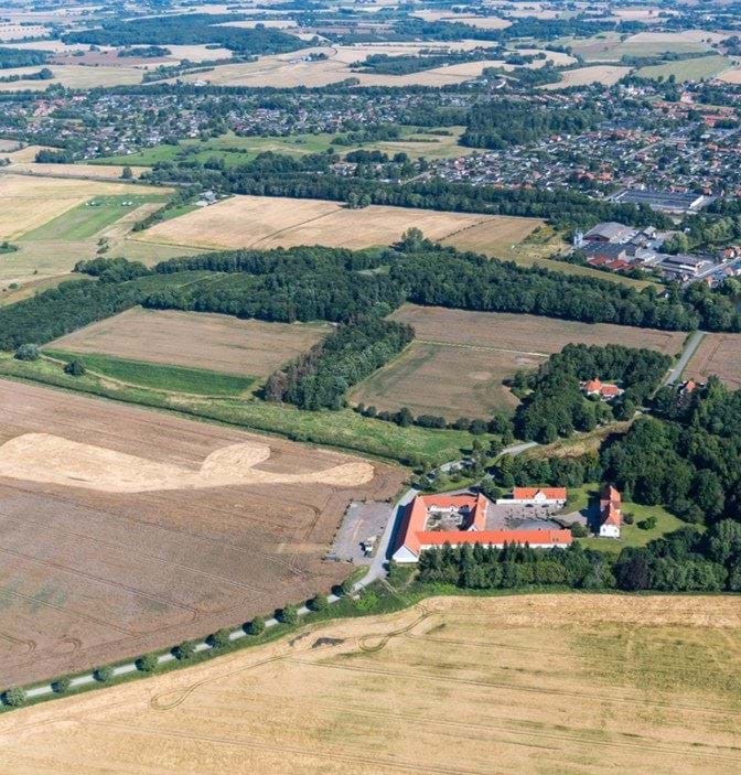 Luftbillede af Ullerslev set fra syd fra det åbne land. En forgrunden ses et gårdanlæg.